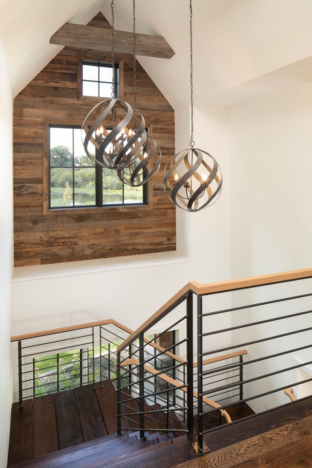 a staircase with a beautiful inset window with reclaimed wood paneling accenting it