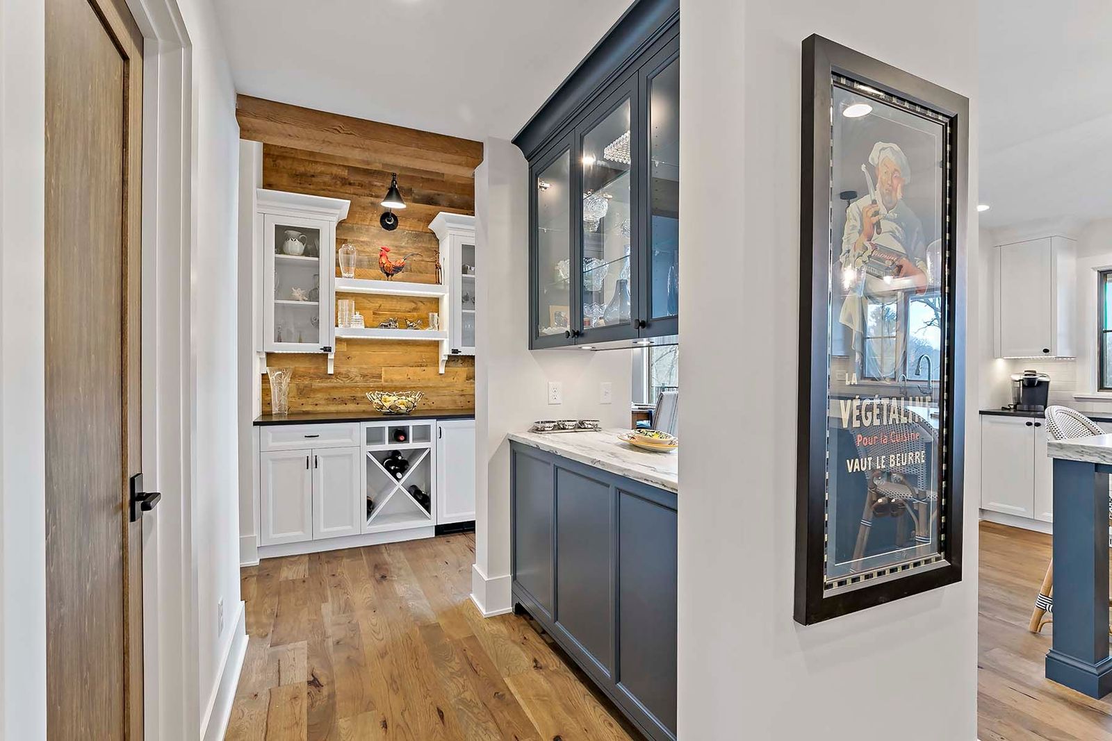 a bar area with reclaimed barn wood behind the cupboards and shelving