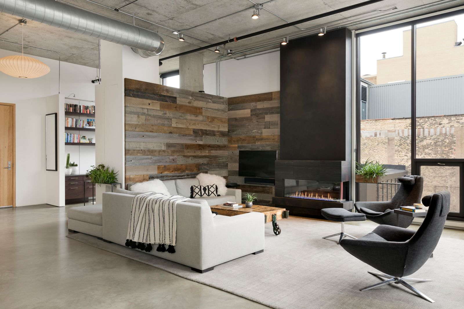 cozy fireplace living room area with a barn wood accent wall in the corner