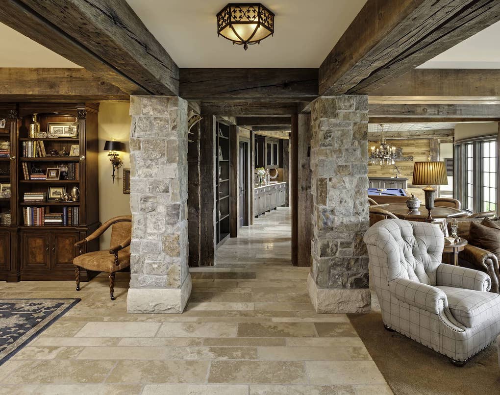 inside large home decorated with reclaimed wood and stone pillars; reclaimed wood wall ideas