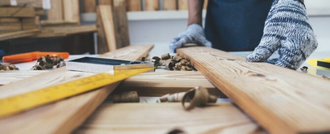 man showing how to clean reclaimed wood on a work bench