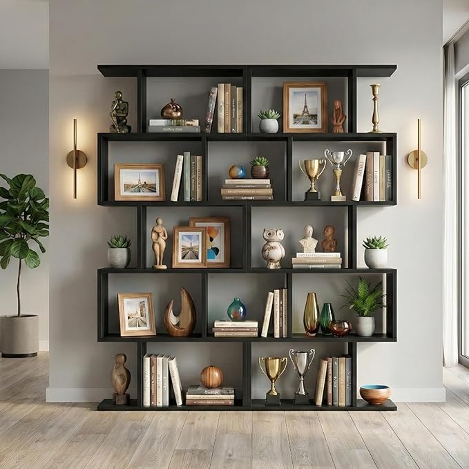 A modern reclaimed wood bookcase filled with books, framed photos, small sculptures, vases, and multiple trophies stands against a light gray wall in a bright room with wooden floors and wall-mounted lights.