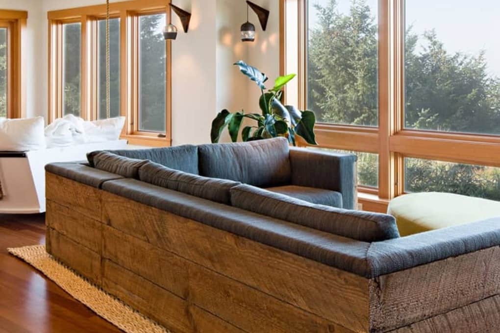 reclaimed wood couch in front of large window