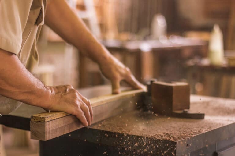 man cutting wood with circular saw for reclaimed wood floating shelves