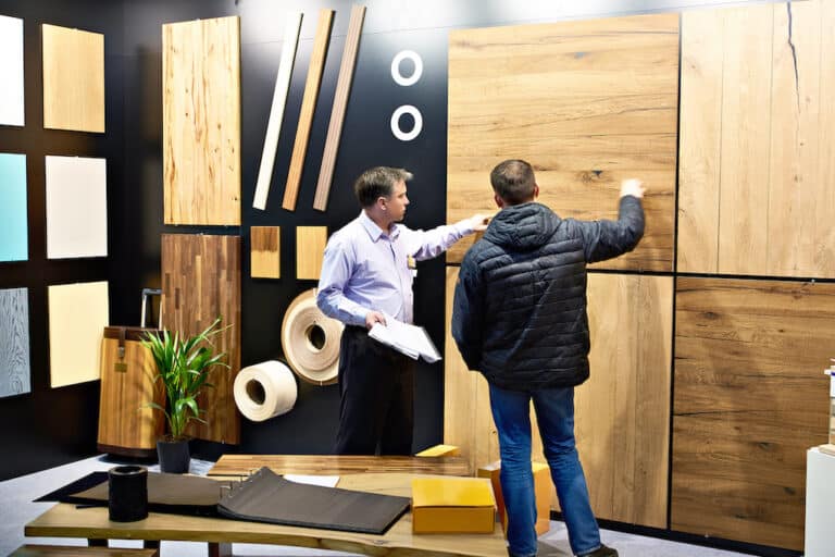 Men in shop of wooden panels for reclaimed wood floating shelves
