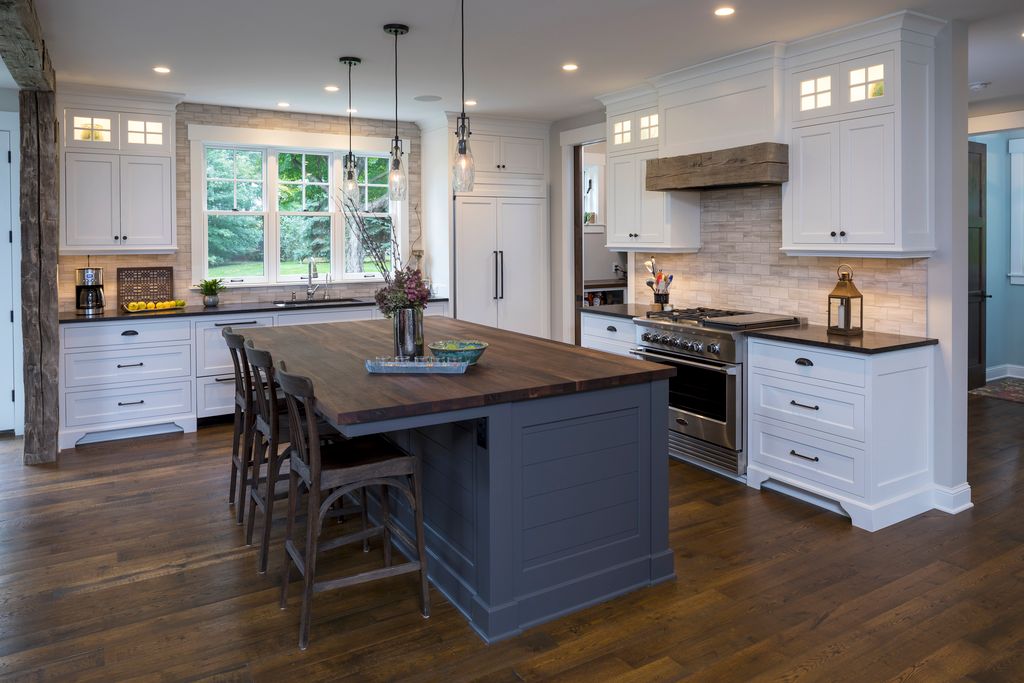 reclaimed wood flooring in kitchen and beam above stove