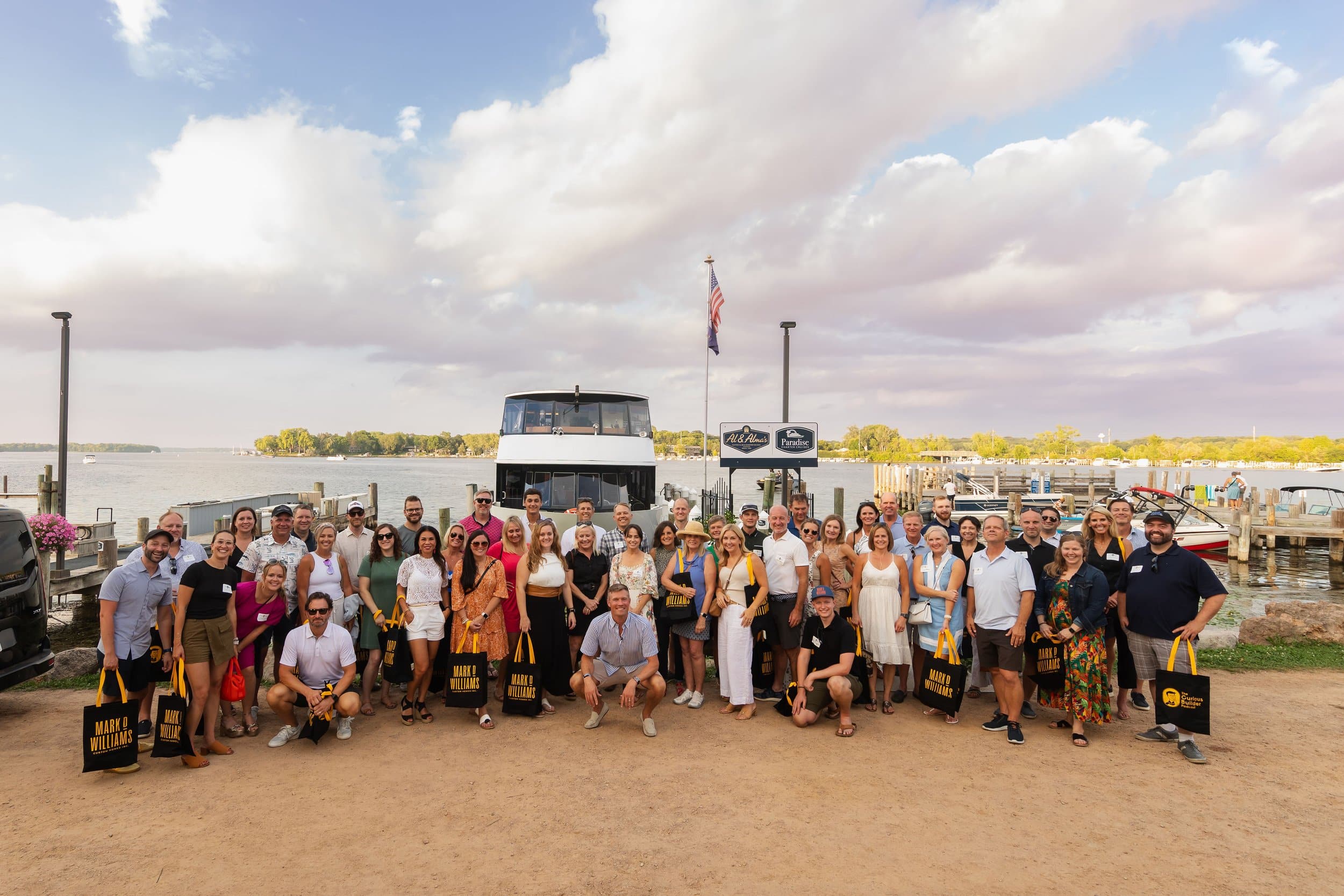 a picture of everyone in front of a boat at the curious builder podcast boat cruise