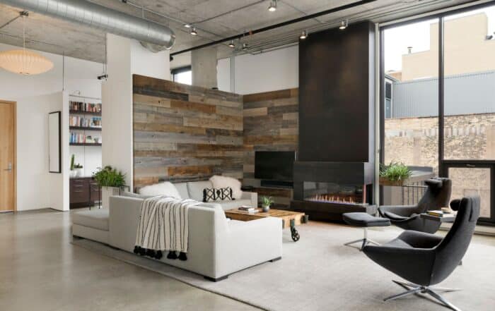 Modern living room featuring a reclaimed wood accent wall behind the TV, showcasing one of many cool wood projects using antique lumber.