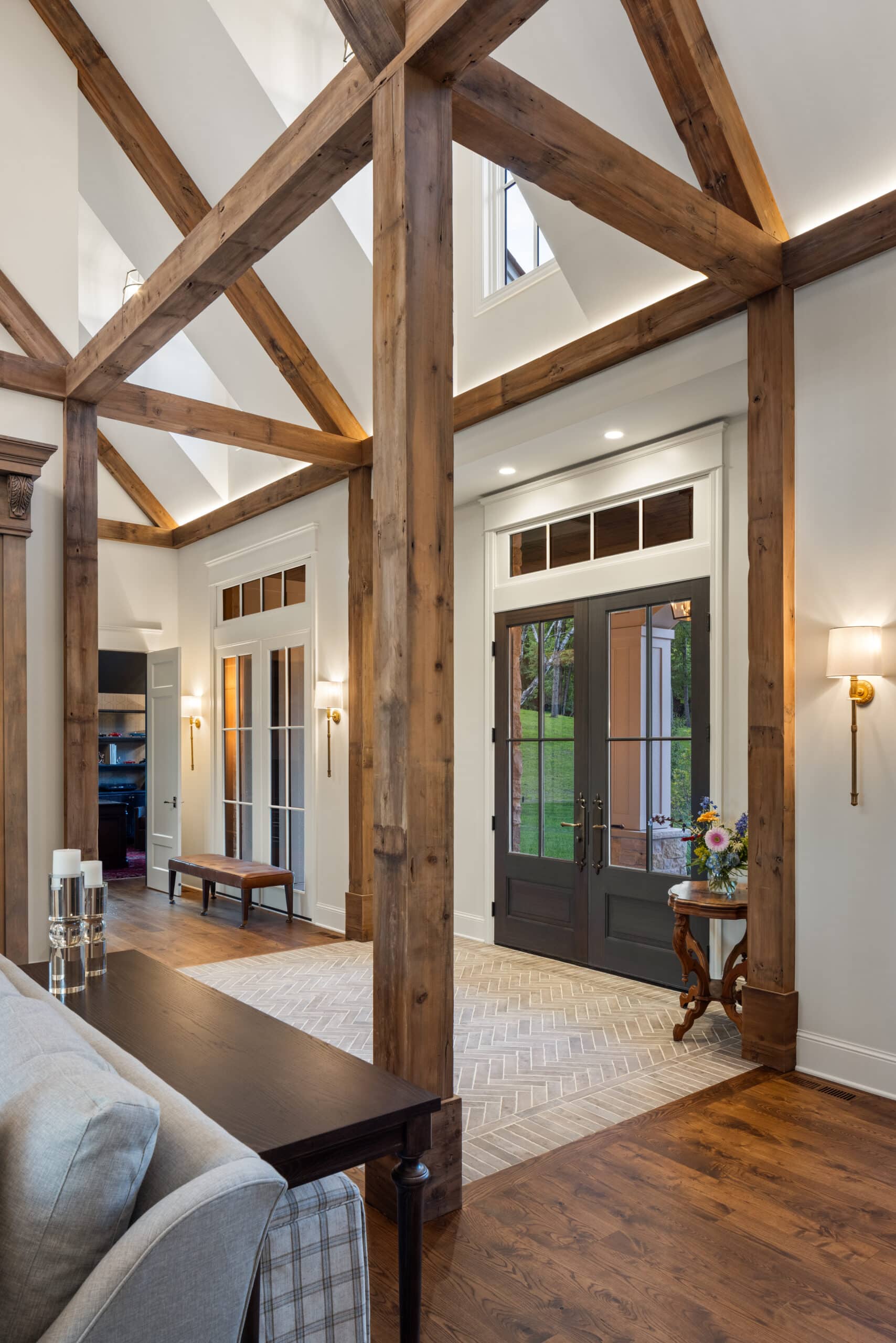 reclaimed wood beams wrapping around the big open floor concept great room with the entry way, all designed by Jim Kuiken