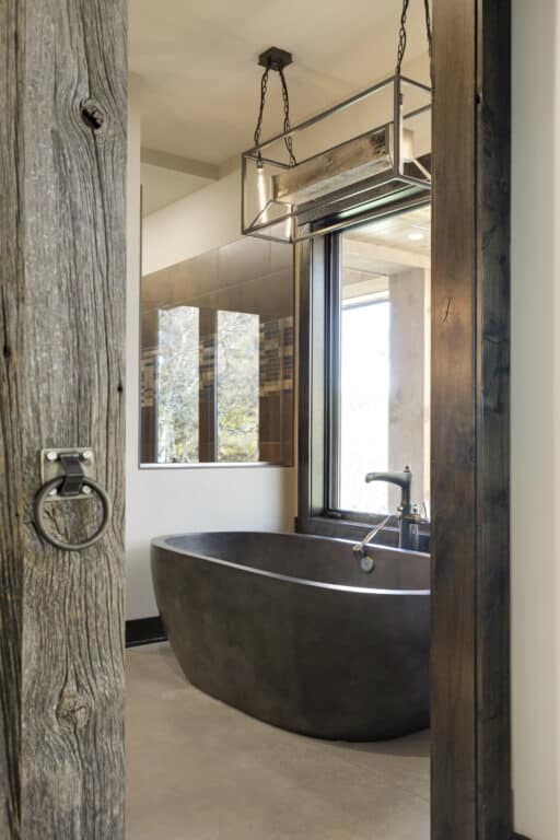 reclaimed wood lighting fixture above a free standing tub in a custom bathroom | Manomin Resawn Timbers