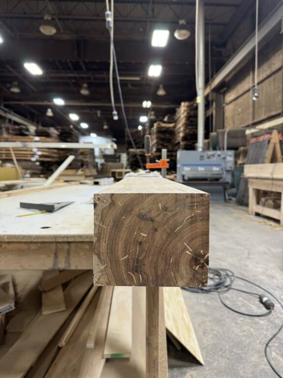 Dense end grain of a reclaimed wood timber of old growth wood. It is sitting in a warehouse wood workshop.