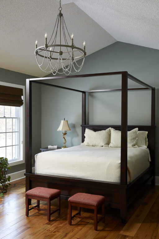 An elegant bedroom with espresso colored pine reclaimed wood flooring.