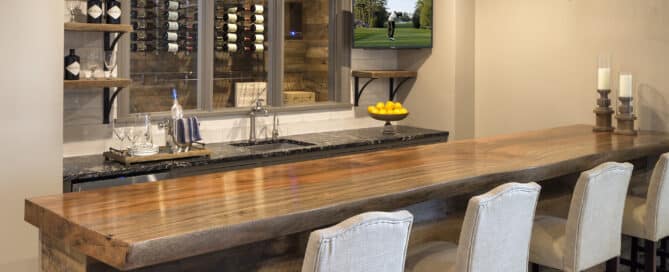 Reclaimed wood bar panels and box beams on the ceiling above. A window shows a wine cellar also built in reclaimed wood.