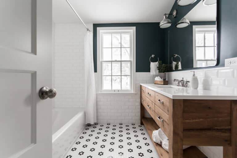 Custom reclaimed wood furniture in a modern bathroom. Bathroom vanity made from reclaimed white oak. White tile on the walls and floors with the upper walls painted a deep blue.