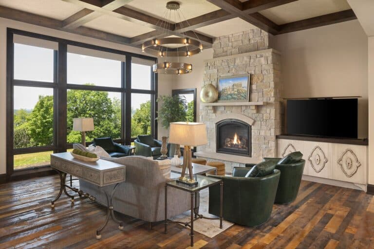 A custom coffered ceiling made from reclaimed Elm wood box beams. Rich hardwood floors and a grand stone fireplace sit beneath.