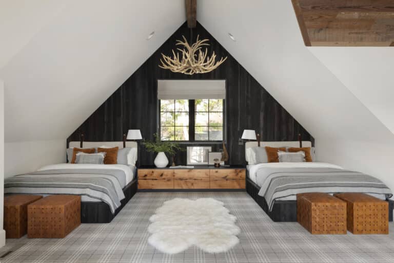 A double bedroom with angled ceilings and an accent wall in Shou Sugi Ban reclaimed wood wall paneling.