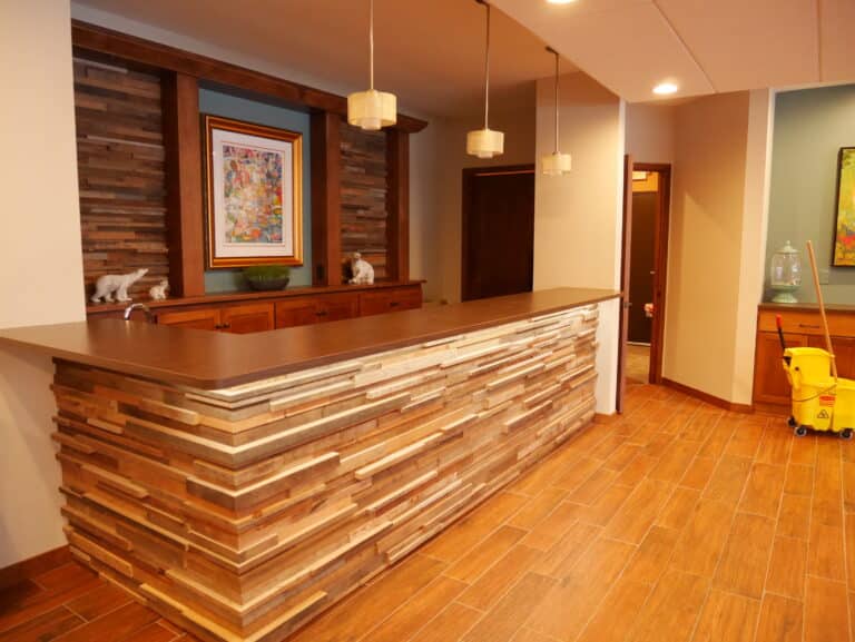 A custom home bar with a front face made from reclaimed wood timber tile paneling.