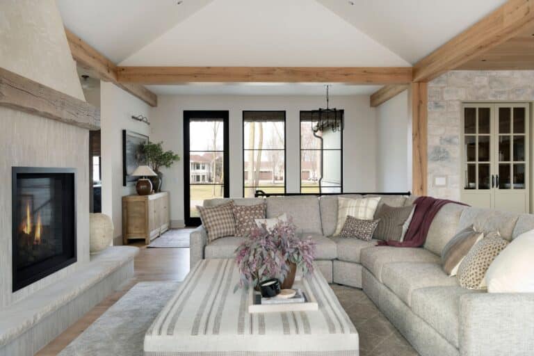 White oak decorative ceiling reclaimed wood box beams outline the perimeter of a bright, modern living room with white walls, a sleek contemporary fireplace, and a comfy sectional sofa.