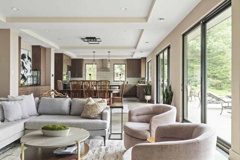 Open concept kitchen living room with modern furniture and natural light in Forest Lake luxury home.