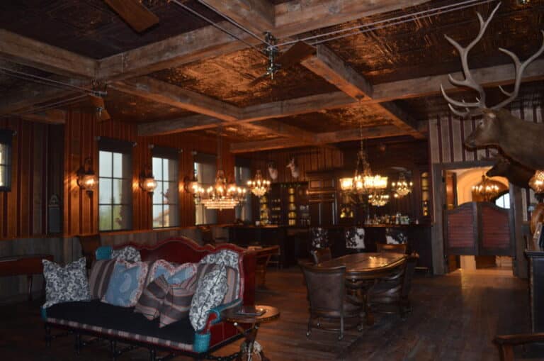 A dark hunting lodge lounge with timber ceilings and reclaimed wormy chestnut flooring.