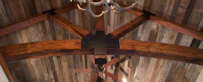 Vaulted ceiling with Wormy chestnut wood paneling and timber trusses.