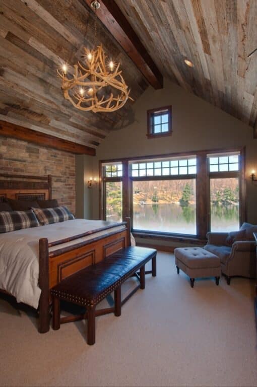 Bedroom with vaulted ceiling of reclaimed wormy chestnut wood paneling.