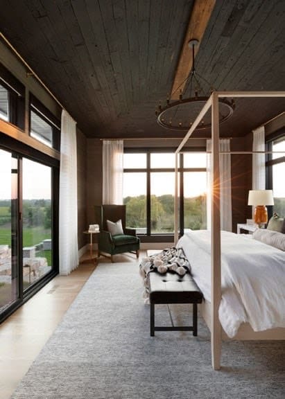 Master bedroom with picture window walls, four poster bed, and Shou Sugi Ban wood ceiling.