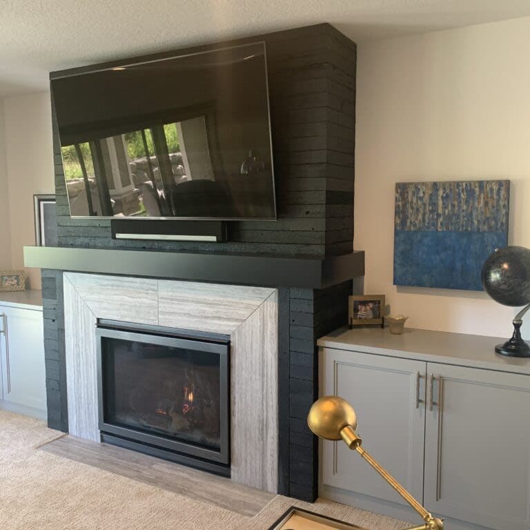 Fireplace with Shou Sugi Ban paneling surround and TV mounted above.