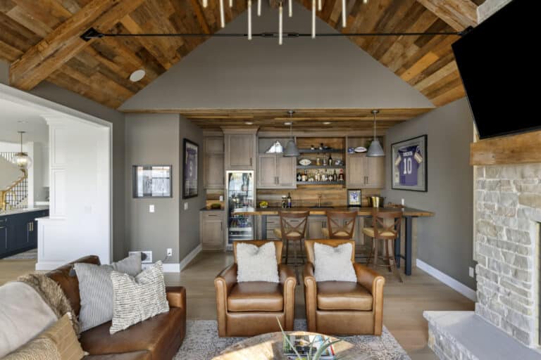 Luxury home great room with reclaimed wood paneling and reclaimed wood timbers on ceiling.