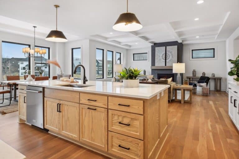 Modern open concept kitchen and living room with dining nook and fireplace in Maple Grove luxury home.