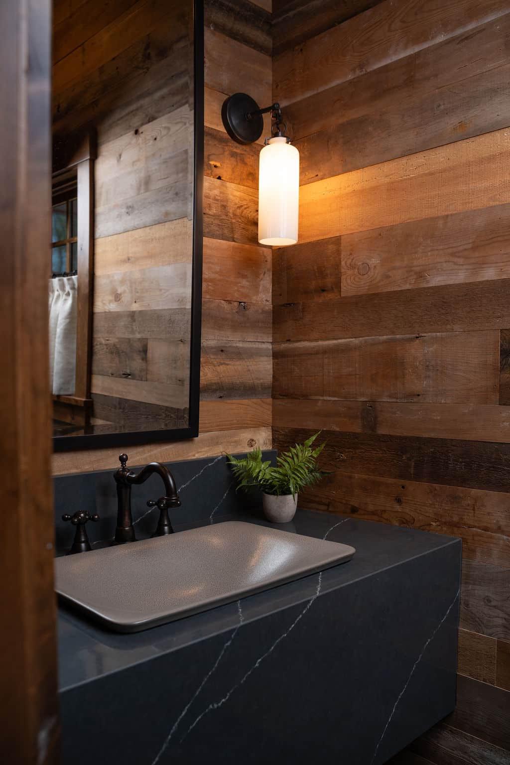 Weathered antique reclaimed wood paneling on bathroom walls above vanity