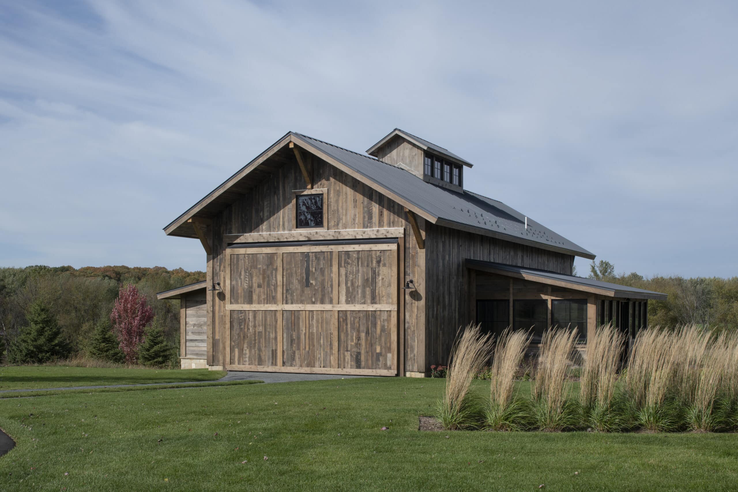Wood barn with reclaimed exterior wood siding in prairie grassland.