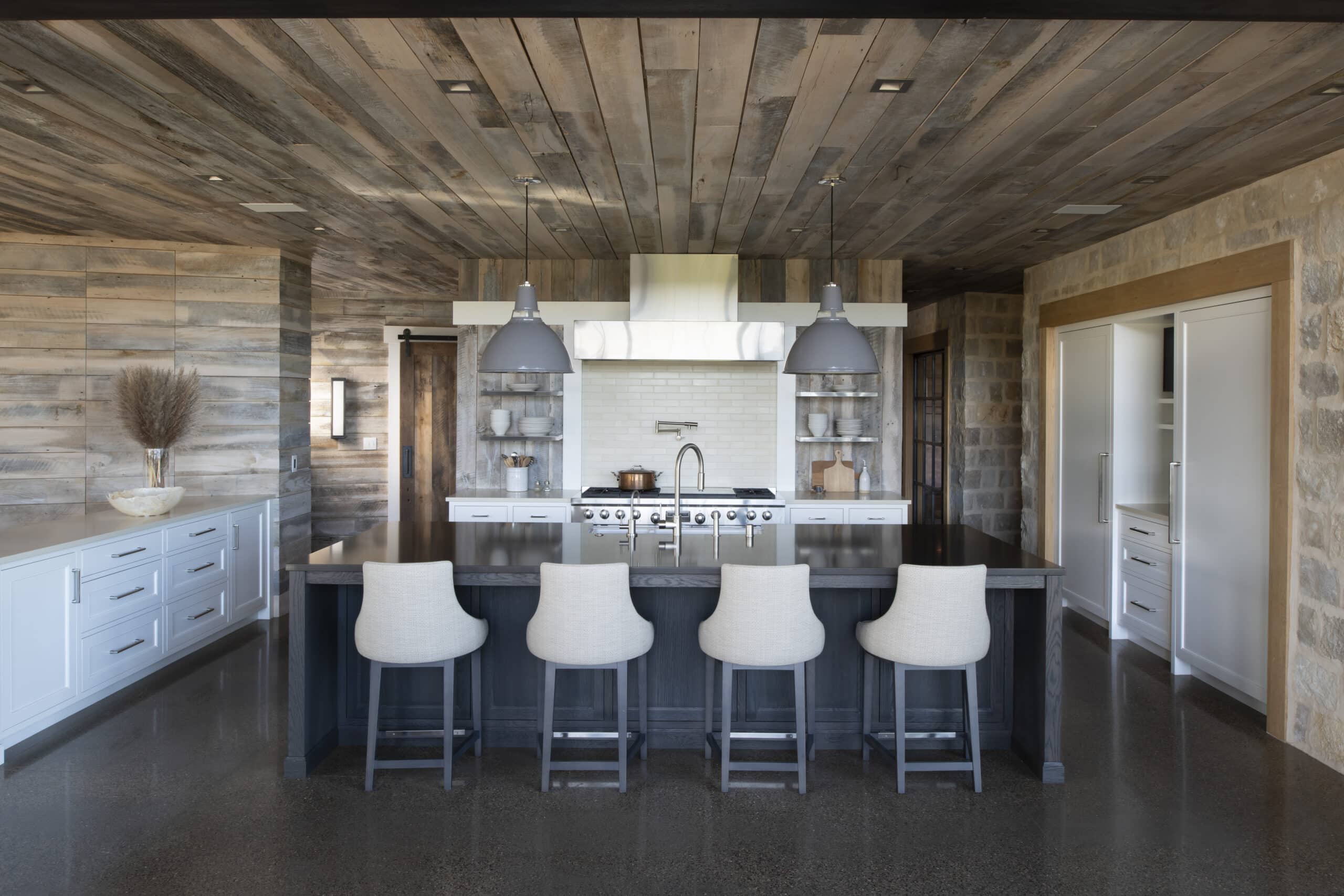 Modern kitchen with stone and reclaimed wood panel walls and reclaimed wood panel ceiling
