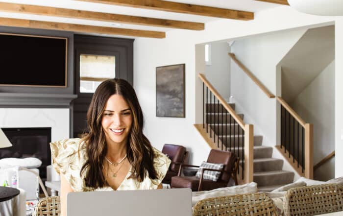 Lifestyle blogger sitting at kitchen island beneath reclaimed wood box beam ceiling
