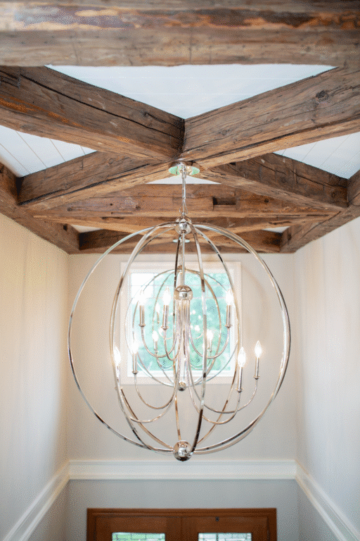 Hand hewn timber crossed decorative ceiling beams with modern light fixture hanging