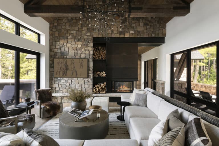 Modern living room with stone walls and industrial style ceiling beams of reclaimed wood and steel