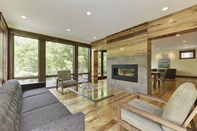 Elm flooring in living room lounge area with modern fireplace and picture windows.