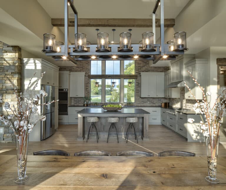 Modern rustic kitchen made with reclaimed wood flooring and box beams and modern hanging custom light fixture