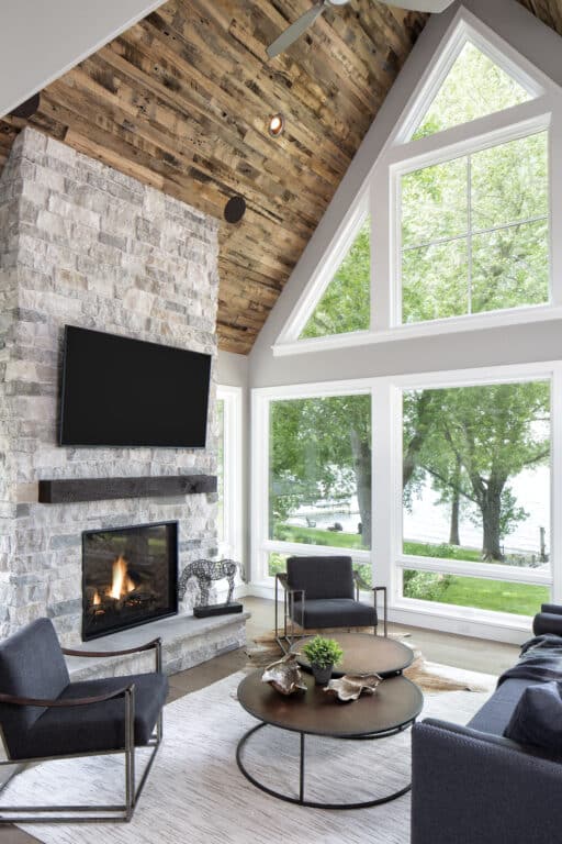 Luxury home design with modern rustic fireplace and reclaimed wood mantel and ceiling paneling