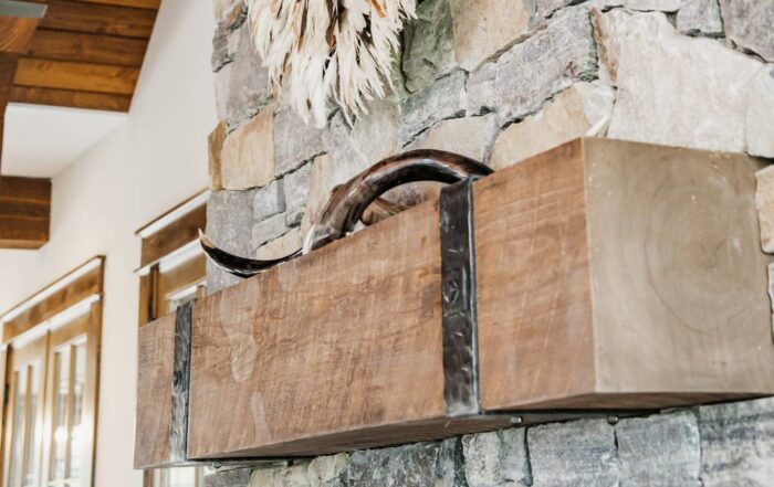 Weathered antique fireplace mantel with iron straps on stone fireplace
