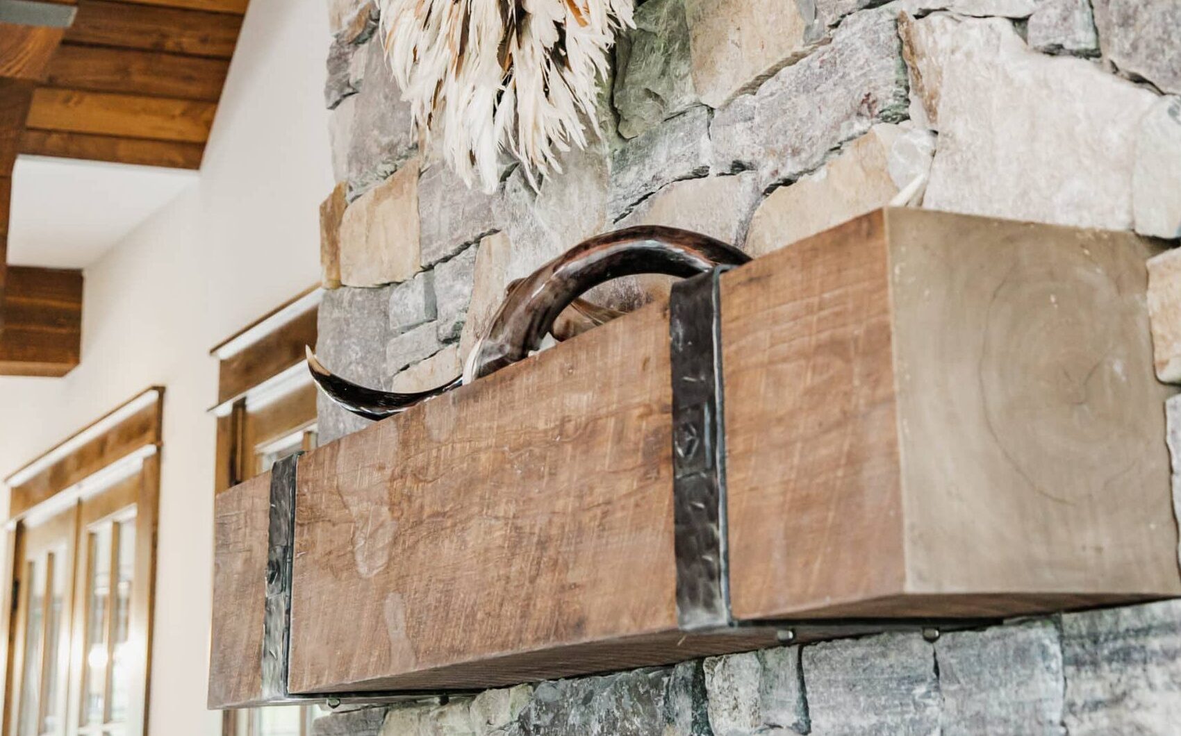 Weathered antique fireplace mantel with iron straps on stone fireplace