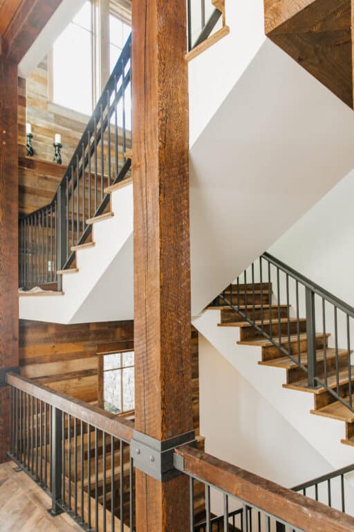 Stairway switchback with skip oak treads and wood vertical beams.