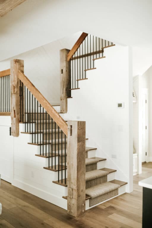 White stairs with weathered antique reclaimed wood newels and handrails.