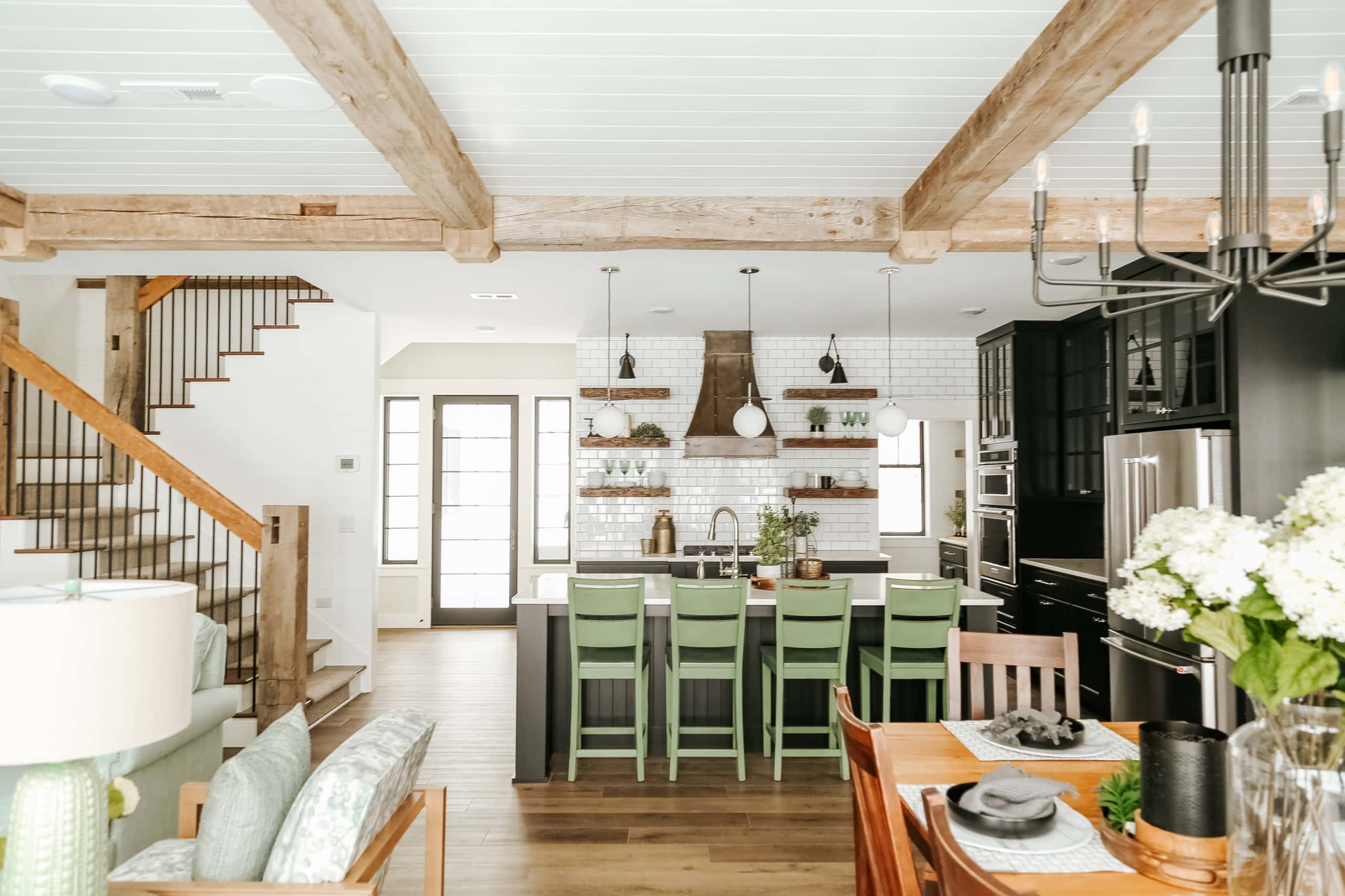 NCB Stairs 3 Open kitchen area with reclaimed wood ceiling beams, newels, and handrails on stairs.