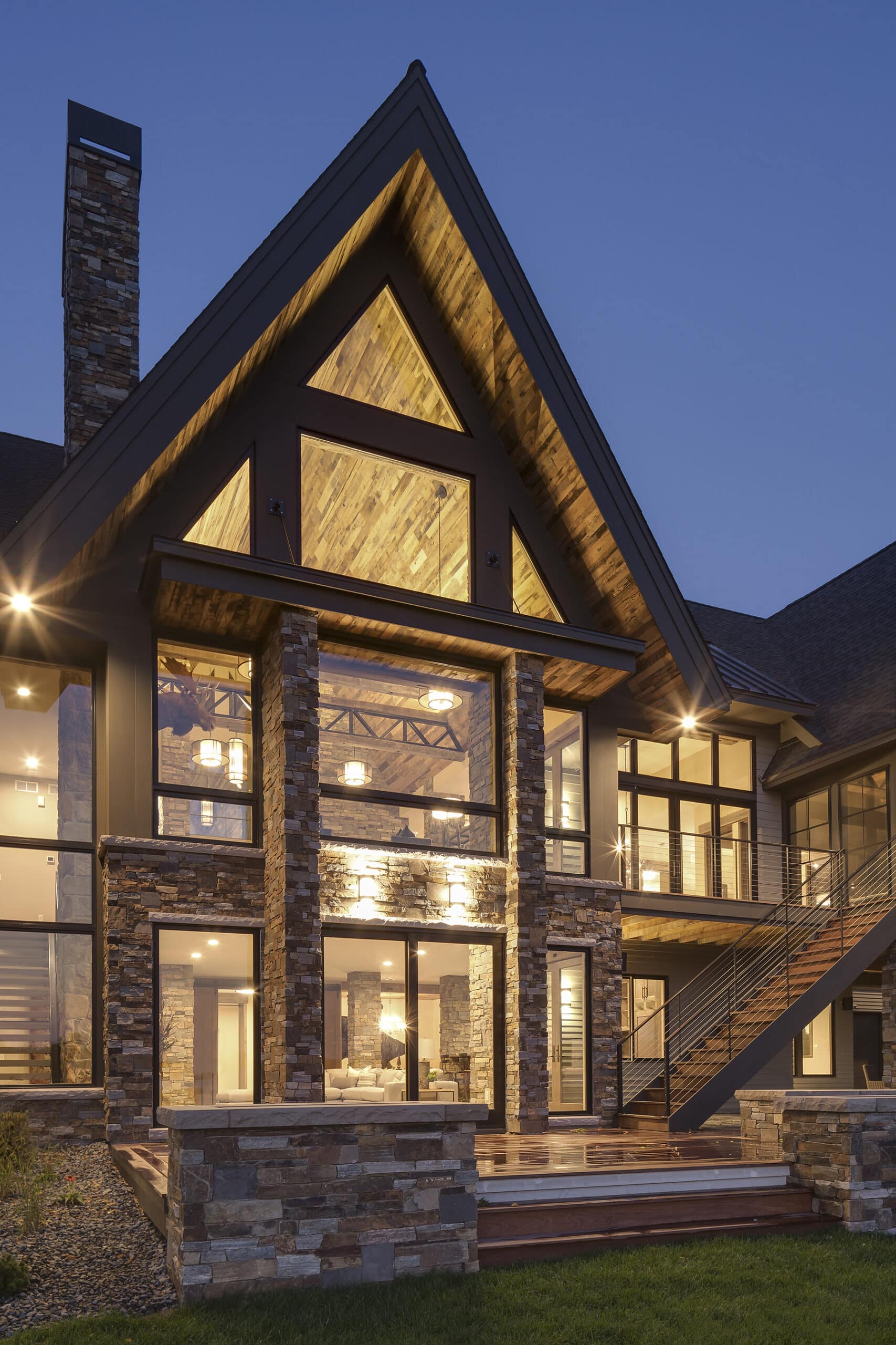 antique skip oak soffit and ceiling Modern rustic lodge at night with glass walls and reclaimed wood soffits on high gables