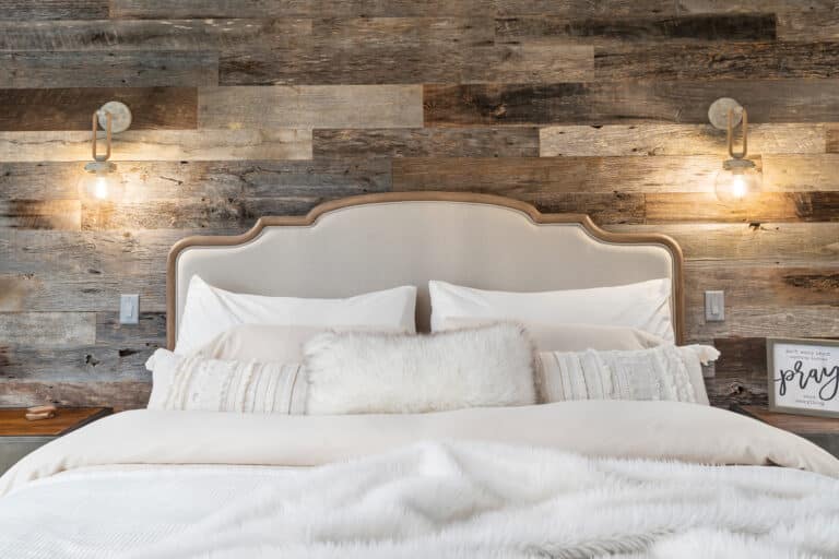 Master bed with weathered gray reclaimed wood accent wall behind headboard