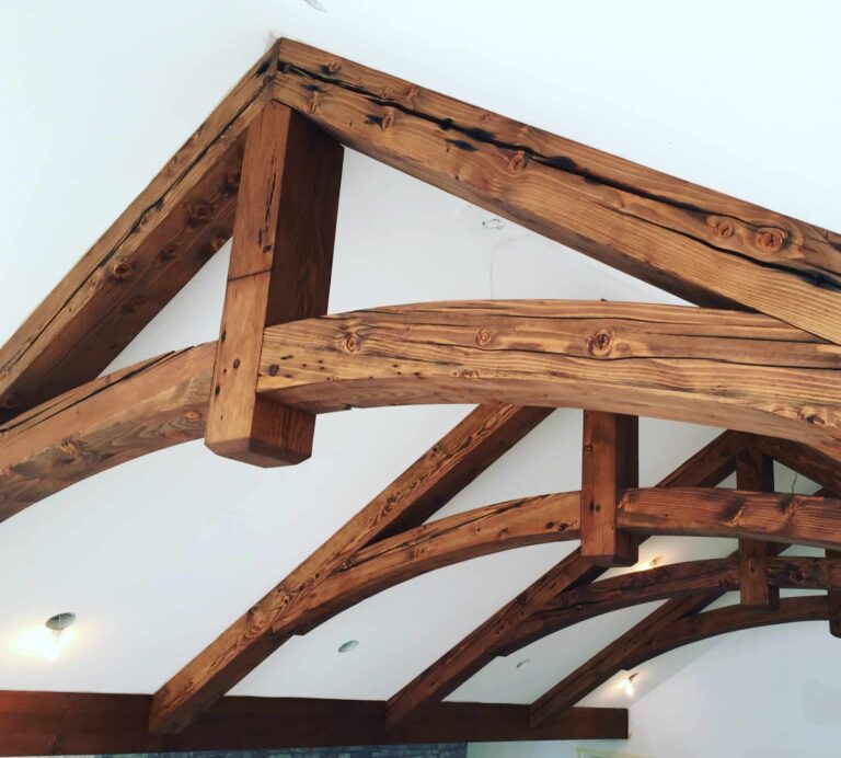 Douglas fir wood ceiling trusses in a vaulted interior, showcasing detailed joinery, visible wood grain, and a natural finish that highlights the warm color and texture of the Douglas fir wood design.