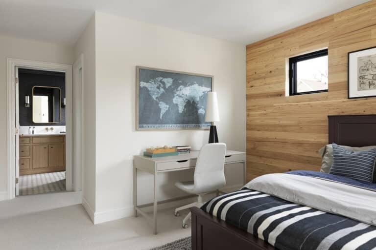 Bright bedroom featuring a reclaimed wood accent wall behind the bed, paired with minimalist decor and a home office setup