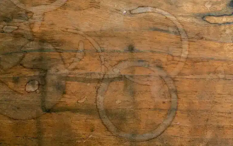 Wood tabletop with visible cup rings and discoloration, demonstrating when it’s necessary to remove stain from wood.