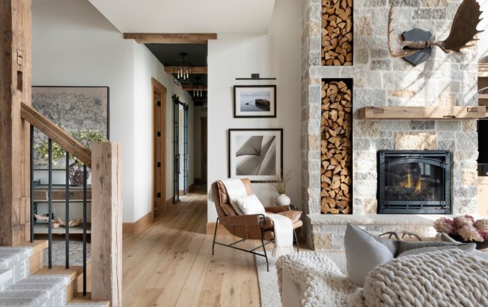 Light-toned reclaimed wood floors paired with a stone fireplace and timber accents, highlighting the warmth and character of the best wood flooring.